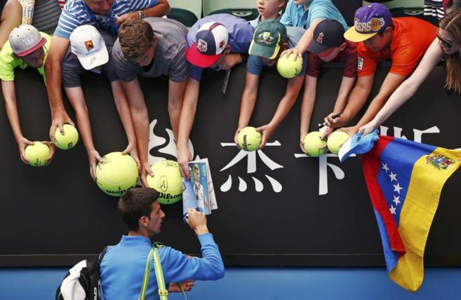 Novak Djokovic firma autgrafos tras su victoria sobre Bedene.