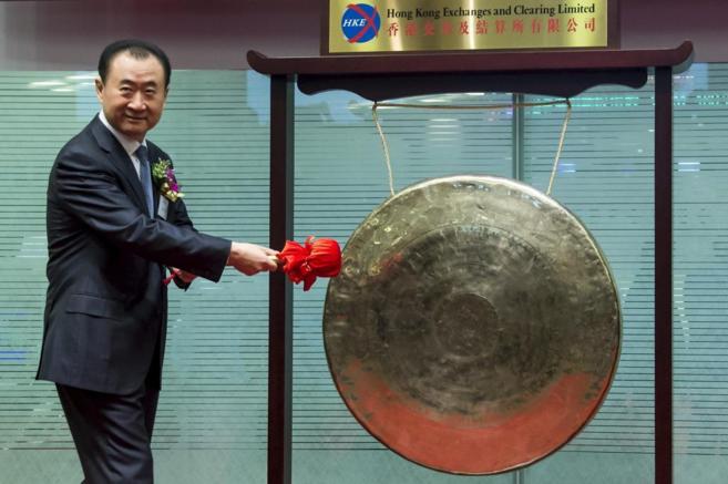 Wang Jianlin golpea un 'gong' para celebrar la entrada de su...