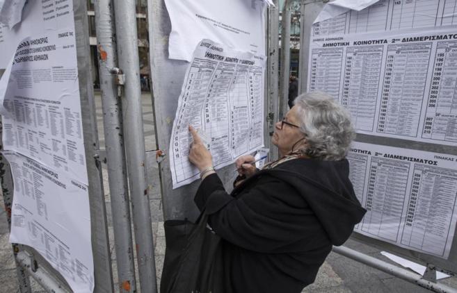 Una mujer consulta las listas electorales en Atenas.