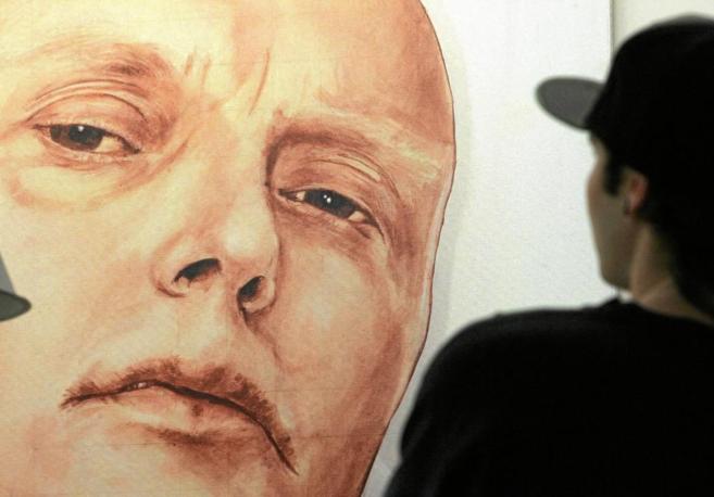 Un hombre contempla un retrato de Alexander Litvinenko, en una...