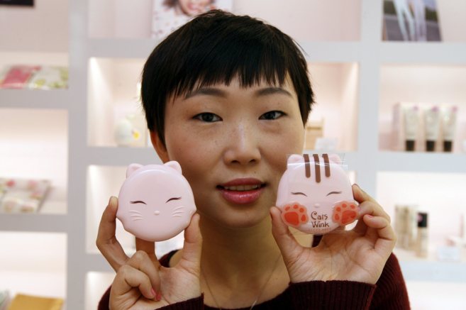 Lilin Yang, la fundadora de Miin, con dos polveras en forma de gato.