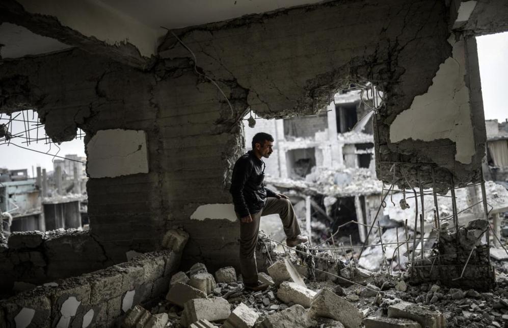 Un hombre kurdo en un edificio destruido del centro de Kobane. Las...
