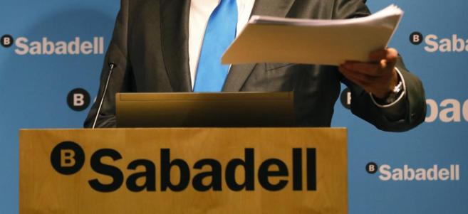 El presidente de Banco Sabadell, Josep Oliu, muestra un 'dossier' de...