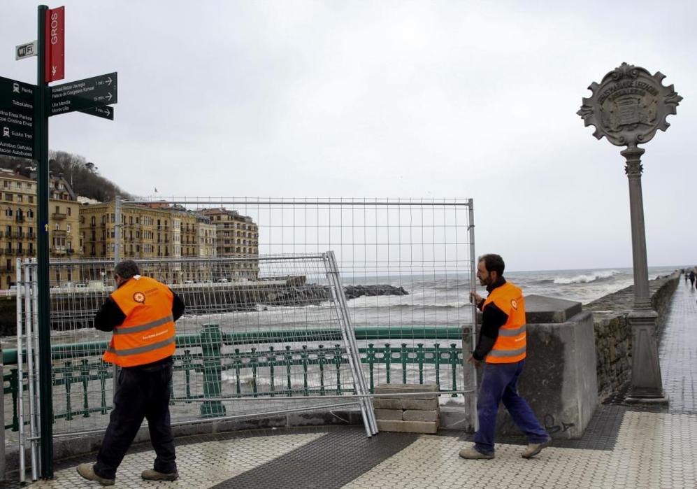 Operarios municipales preparan vallas protectoras en el puente del...