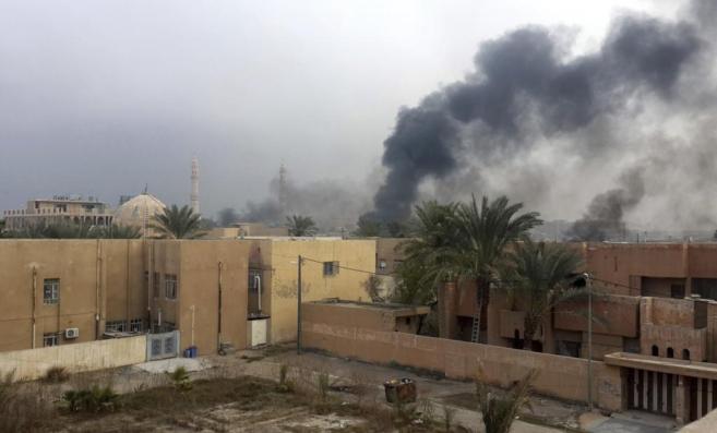 Una columna de humo se eleva de varios edificios en Irak tras varios...