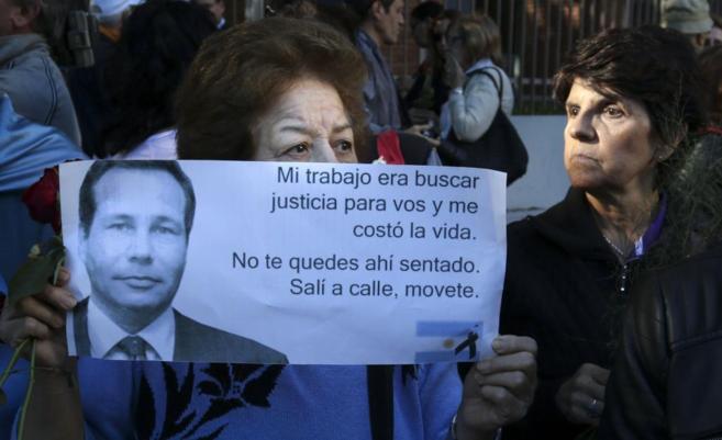 Una mujer sostiene un cartel con un mensaje del fiscal Alberto Nisman...