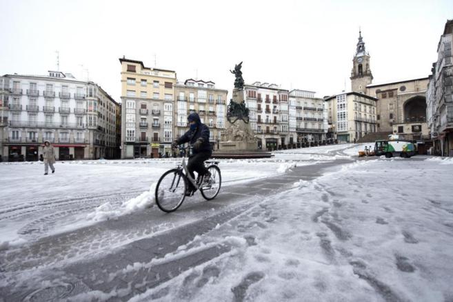 Un ciclista en el centro de Vitoria, cubierta de nieve.