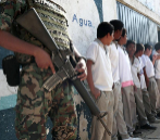 Un soldado vigila la entrada de unos alumnos a su escuela de Acapulco.