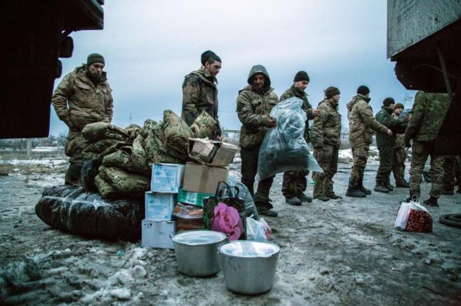 Militares ucranianos cargan con ayuda humanitaria en la localidad de...