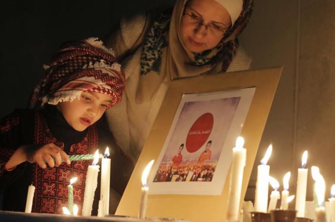 Una nia jordana enciende una vela en recuerdo de los rehenes...
