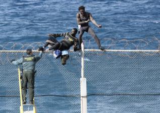 Dos de los inmigrantes encaramados a la valla de Ceuta.