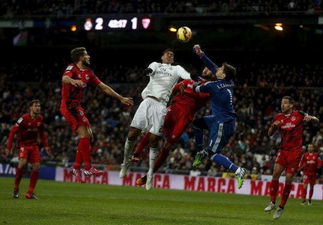 Iker Casillas despeja el baln en un salto con Raphael Varane,...