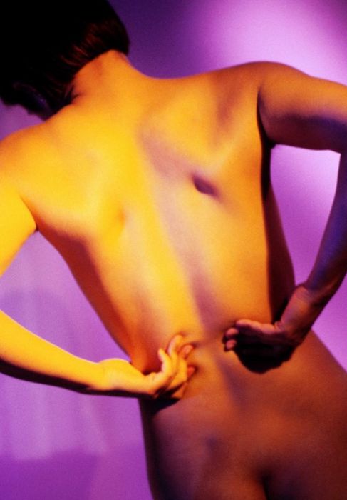 Una mujer se toca la espalda por el dolor de una lumbalgia