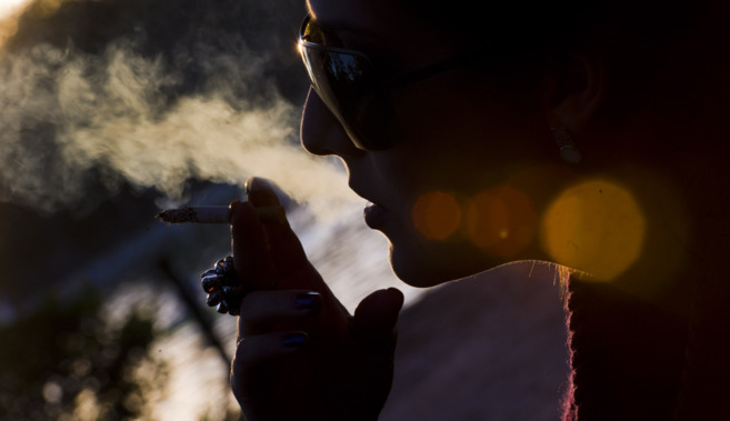 Una mujer fuma en el Parque del Retiro de Madrid.