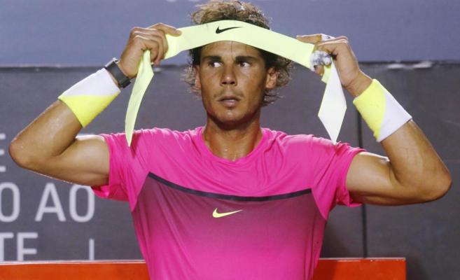 Rafael Nadal ajusta la cinta de su cabeza durante un descanso del...