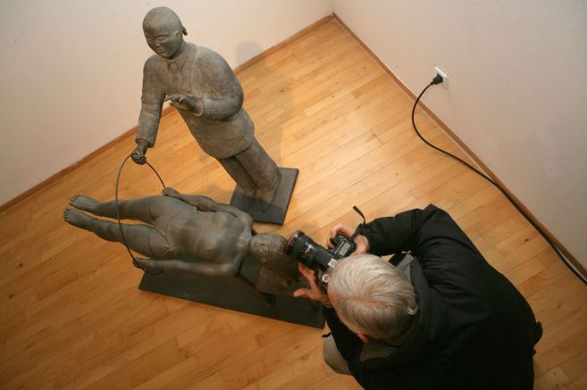 Un fotgrafo tom imgenes ante una escultura de Jos Seguiri.