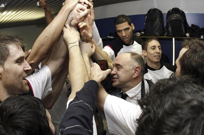 Los jugadores del Real Madrid unen sus manos en el vestuario.