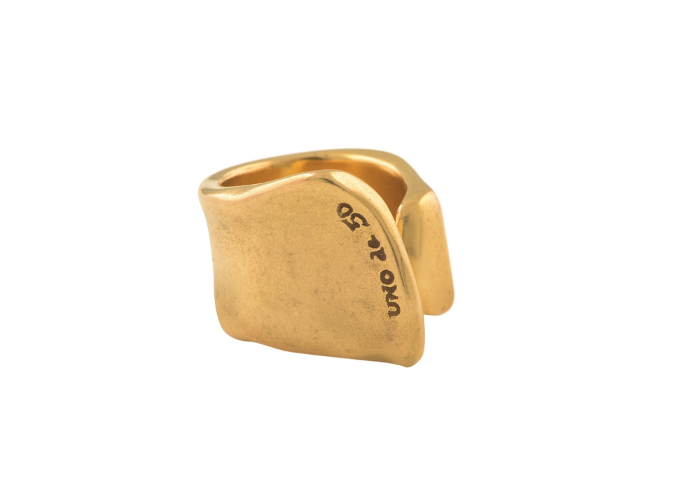 La grieta, un anillo con hendidura y el logo UNO de 50, baado en oro...