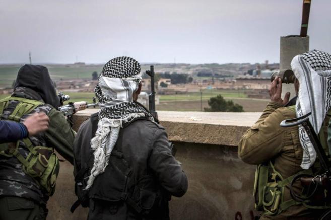 Miembros de las Unidades de Proteccin kurdas observan la ciudad...