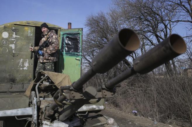 Un soldado ucraniano, en un arma de artillera pesada cerca de...