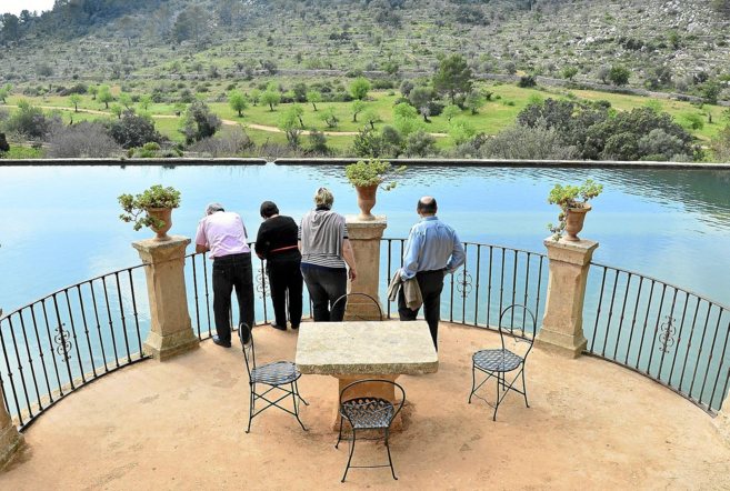 Cuatro visitantes observan el paisaje de Raixa.