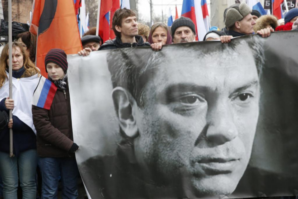La gente sostiene una bandera con la imagen del crtico del Kremlin...