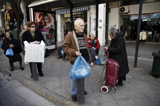 Varias personas salen de comprar en un mercado de Atenas