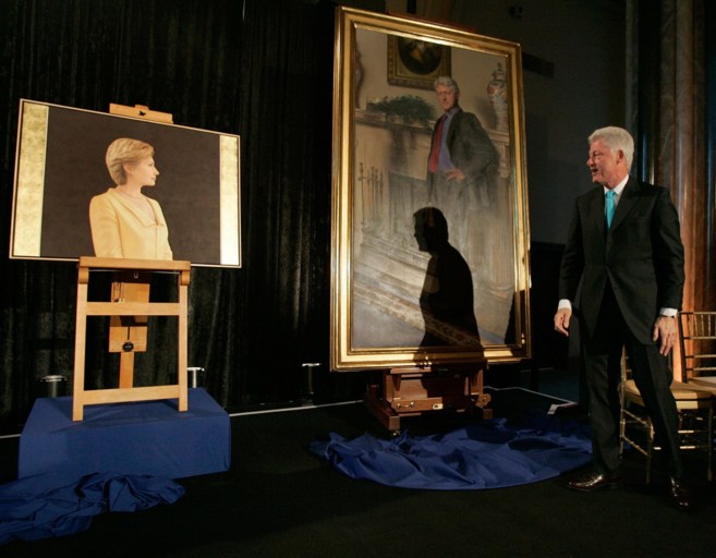 Clinton, ante el retrato de la polmica y un retrato de su esposa, en...