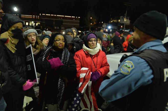 Varios manifestantes frente a un agente en Ferguson la pasada...