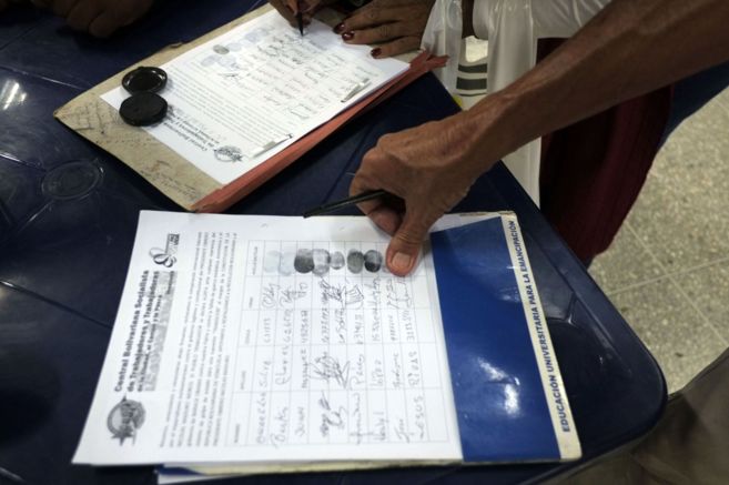 Un hombre firma en Caracas un documento de apoyo al gobierno...