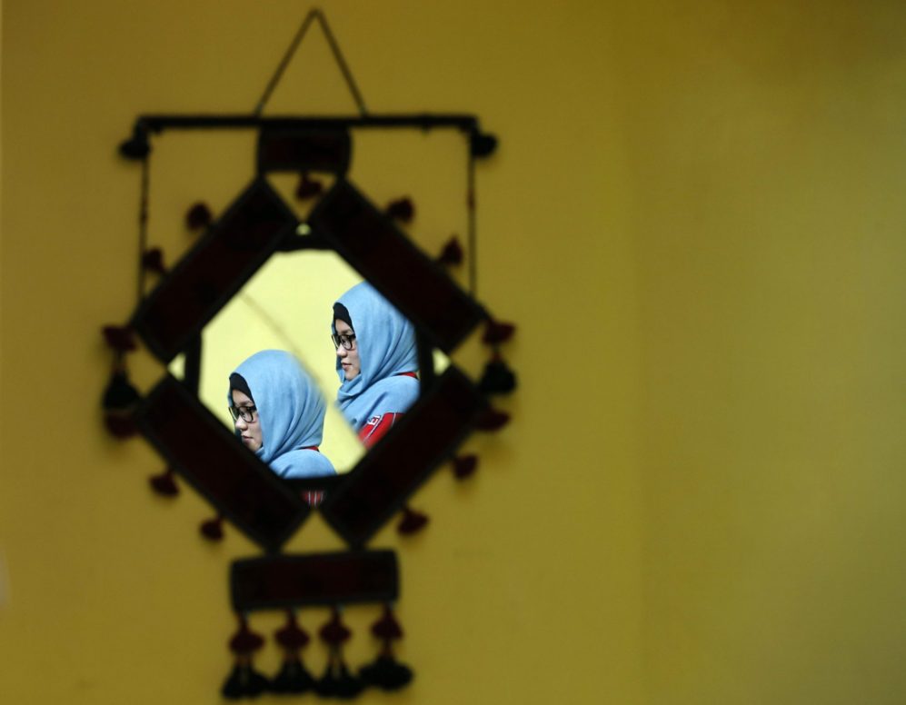 Masooma Alizada se refleja en un espejo mientras espera en su casa que...