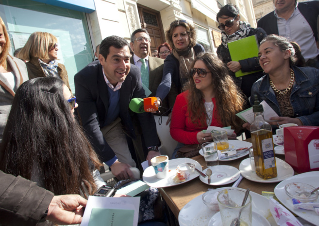 Juan Manuel Moreno conversa con unas jvenes que desayunaban en una...