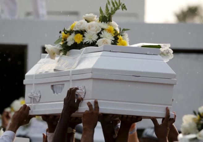 Familiares de un nio muerto en Colombia portan su atad blanco.