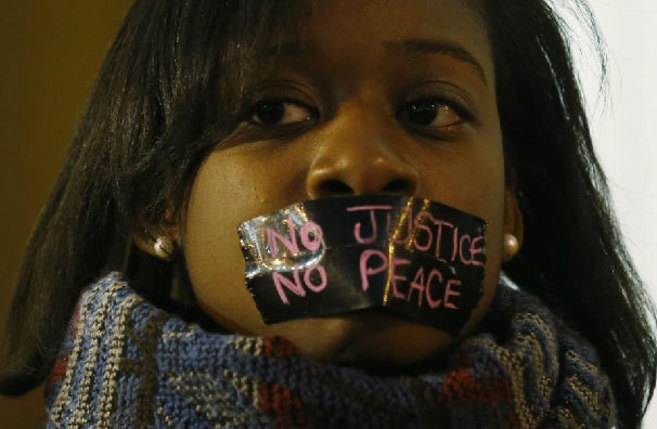 Una manifestante protesta en Ferguson con la boca sellada por la...