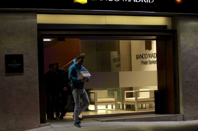 Un agente de la Polica Nacional abandona la sede de Banco Madrid,...