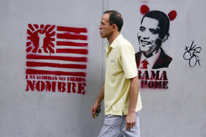 Un hombre camina por Caracas frente a pintadas antiestadounidenses.