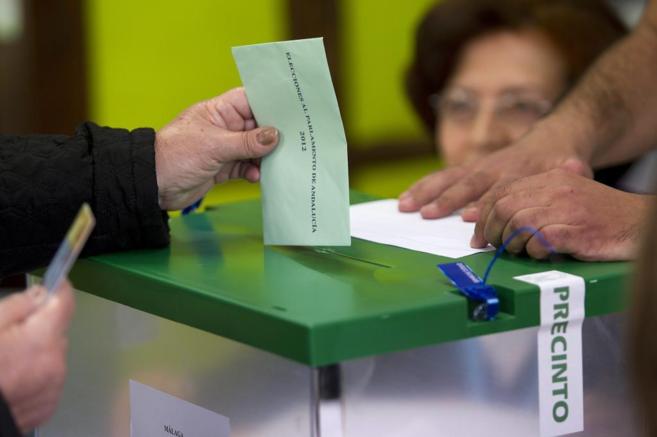 Un elector introduce su voto en un colegio electoral de Mlaga, en...