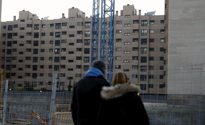 Una pareja de jvenes observa una promocin de viviendas en el PAU...