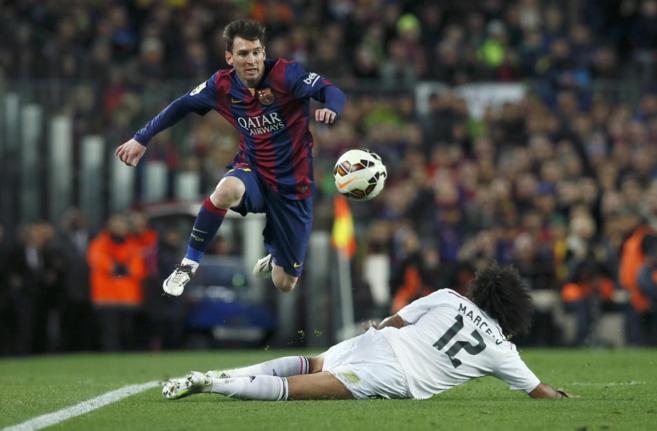 Marcelo intenta frenar la escapada de Messi.