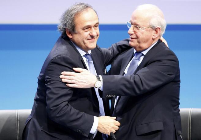 Platini abraza al vicepresidente de la UEFA, Senes Erzik.