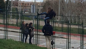 Unos estudiantes intentan acceder al campus de Somosaguas saltando una...