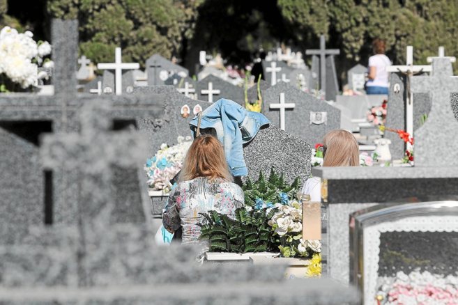 Dos personas visitan a un familiar en el Cementerio de Alicante.