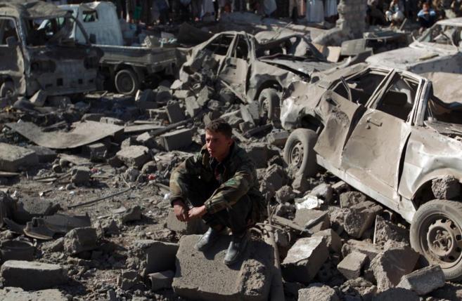 Un yemen se asienta sobre las ruinas provocadas por un bombardeo...