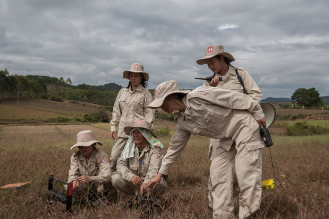 Un equipo de mujeres limpia la zona de bombas racimo en Laos.