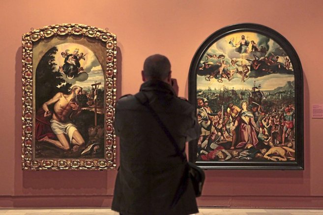 Un espectador observa dos de los cuadros de la exposicin del Museo...