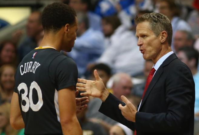 Steve Kerr habla con Curry, durante un partido de la NBA.