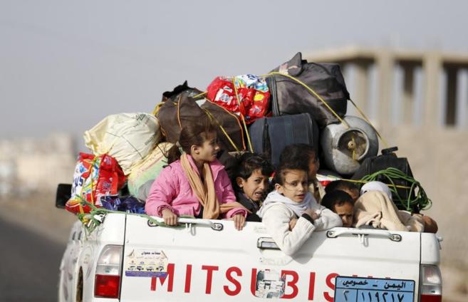 Un grupo de nios huye en una camioneta de los combates en San.