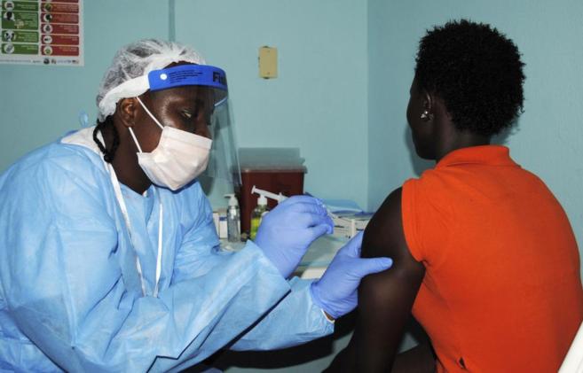 Una mujer recibe una vacuna experimental contra el ébola en un ensayo...