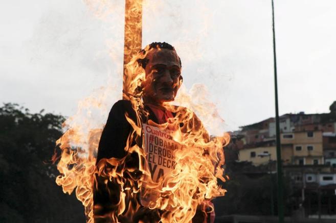 Un grupo de manifestantes quema un mueco con la cara de Barack...