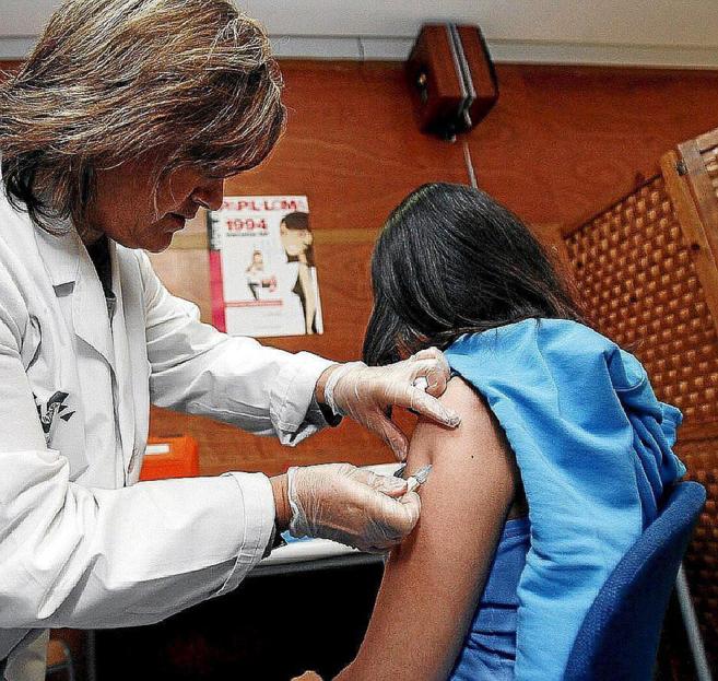 Una enfermera vacuna a una menor durante la campaña de inmunización...